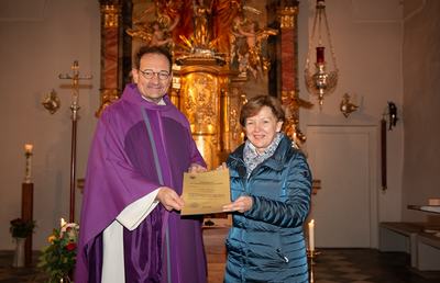 Vikar Gerhard Hatzmann überreicht das Dekret zur Wortgottesdienstleiterin an Christa Pichler